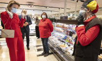 Belgium's Queen Mathilde, left, wearing a mouth mask, speaks with employees during an official visit to a supermarket, during a partial lockdown to prevent the spread of the coronavirus, COVID-19, in Gerpinnes, Belgium, Wednesday, May 6, 2020. (Benoit Doppagne, Pool Photo via AP)