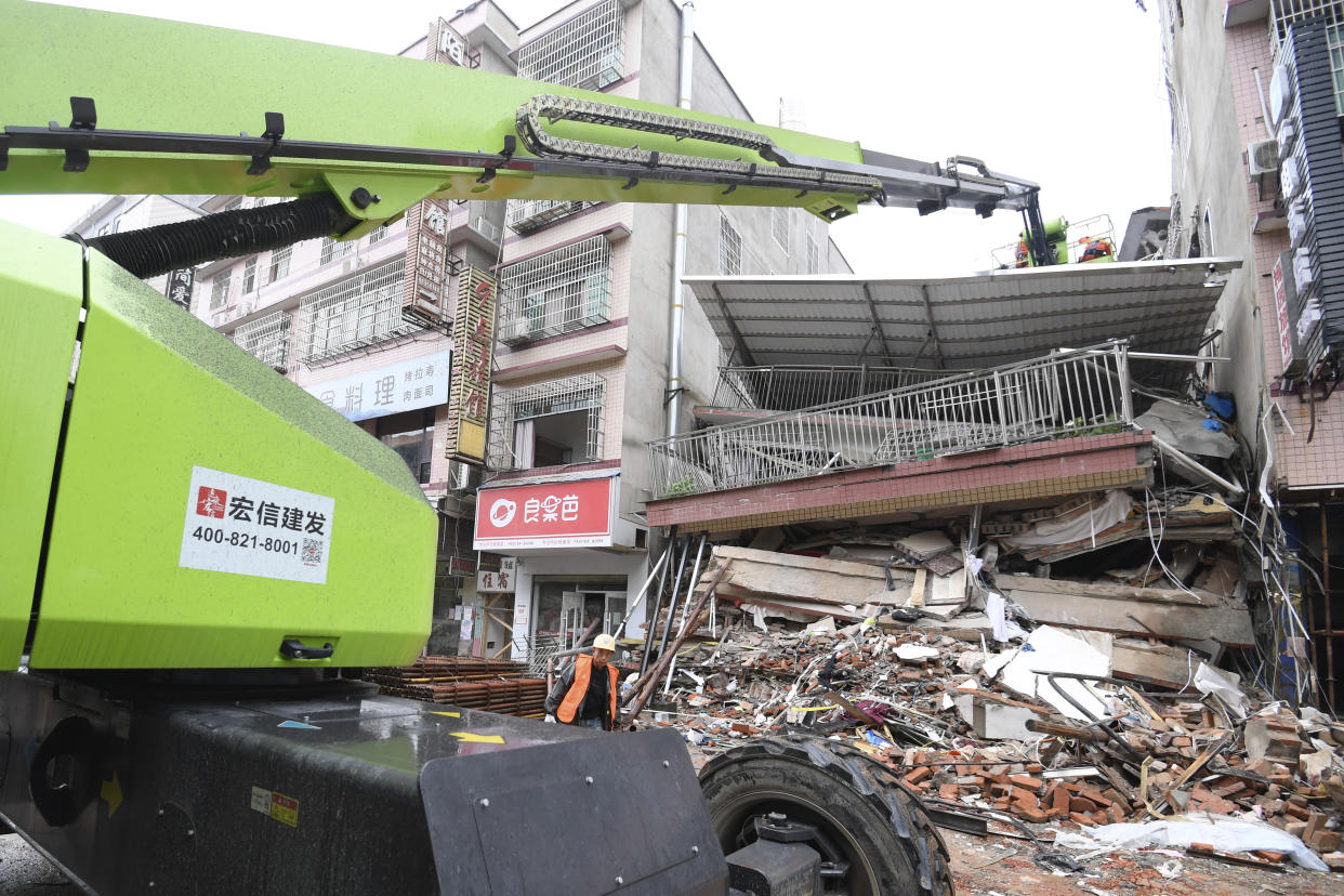 In this photo released by Xinhua News Agency, rescue workers work from a crane over the collapsed site of a self-constructed residential building in Changsha, central China's Hunan Province, April 30, 2022. Rescuers in central China have pulled out alive some of those trapped ina partially collapsed building, authorities said Saturday, while President Xi Jinping gave instructions to rescue the victims "at all costs." (Shen Hong/Xinhua via AP)