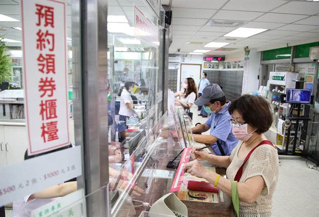 中華郵政全台郵局，開放已預約民眾領取紙本五倍券，13日一早民眾前往郵局預約櫃台領券。(陳俊吉攝) 