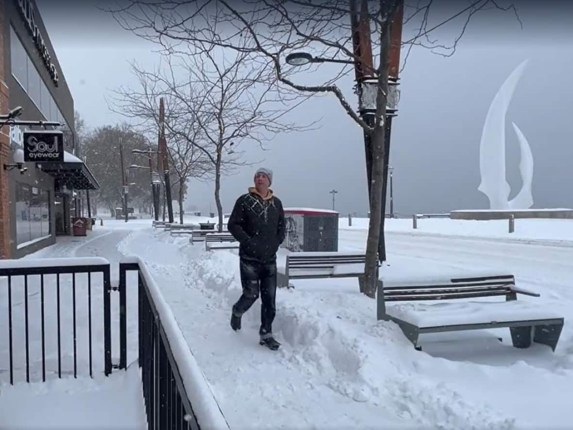 A man walks along Bernard Avenue in downtown Kelowna on Tuesday morning. The City of Kelowna says it has extended the operating hours of its 24-passenger emergency warming bus at the Rail Trail to 5 p.m.-9 a.m. until Saturday. (Tom Popyk/CBC - image credit)