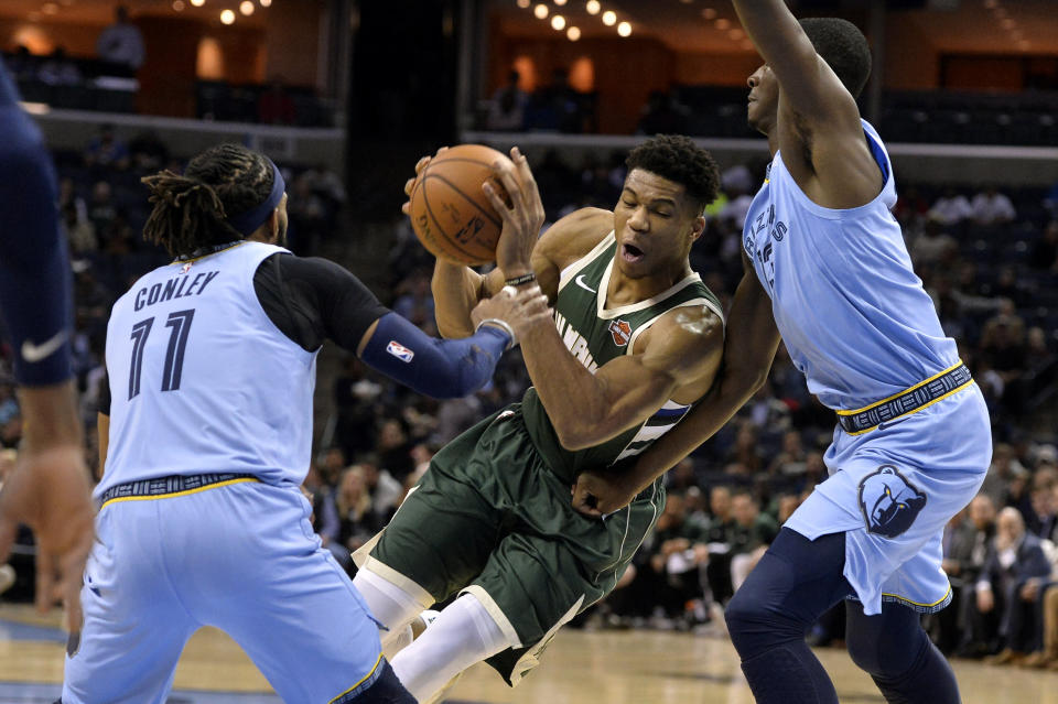 Milwaukee Bucks forward Giannis Antetokounmpo, center, drives between Memphis Grizzlies guard Mike Conley (11) and forward Jaren Jackson Jr. in the first half of an NBA basketball game Wednesday, Jan. 16, 2019, in Memphis, Tenn. (AP Photo/Brandon Dill)