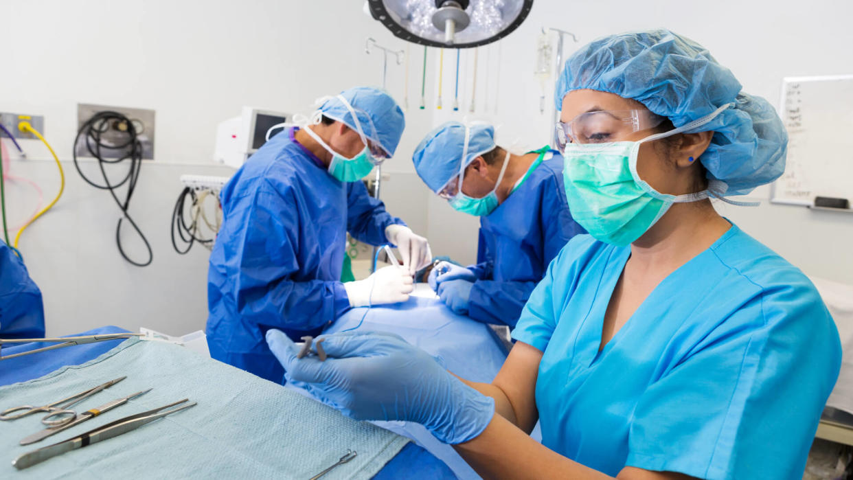 Surgical technologist is prepping instruments for surgeons