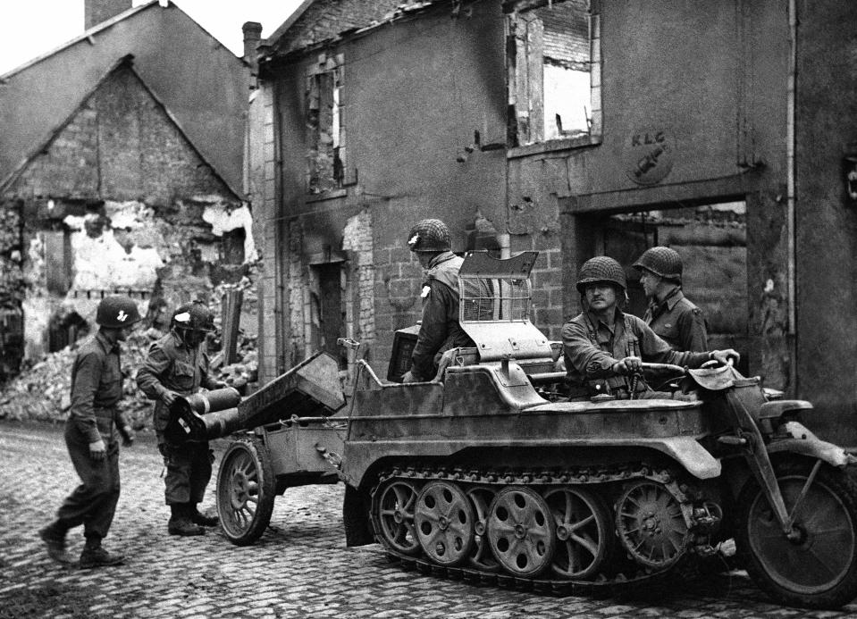 FILE - Men of an airborne unit use a German half-track motor-cycle to carry their ammunition and supplies in the Carentan area of Normandy on June 17, 1944. (AP Photo, File)