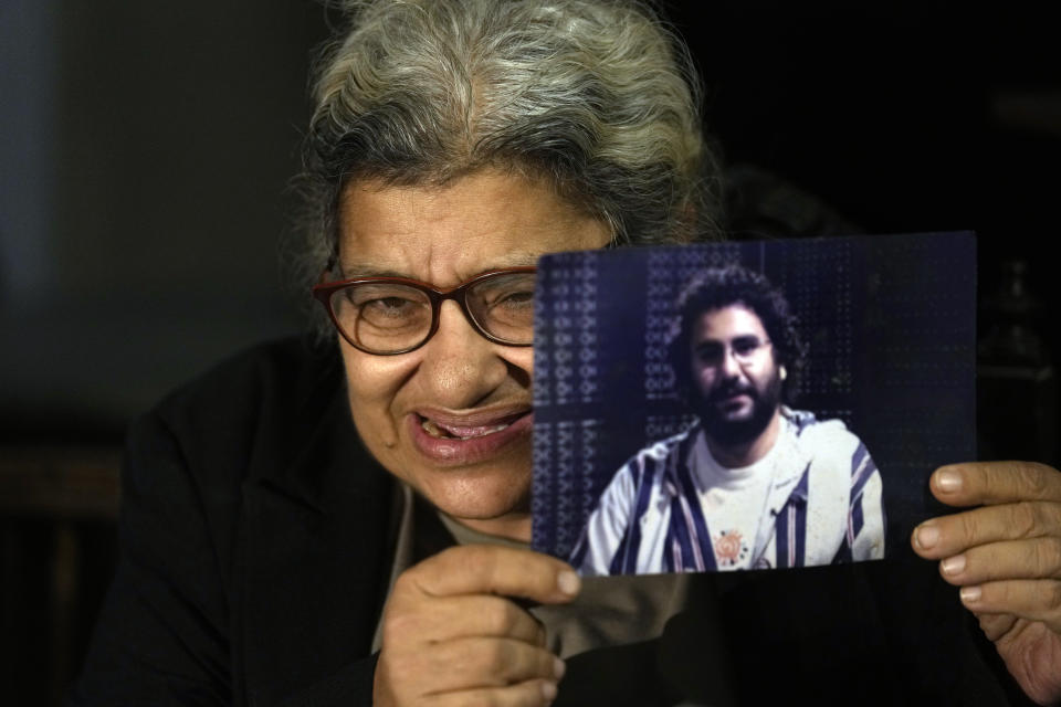 Laila Soueif, mother of jailed pro-democracy activist Alaa Abdel-Fattah, who this week escalated a food and water strike demanding his release, holds his picture during an interview with the Associated Press at her home in Cairo, Egypt, Thursday, Nov. 10, 2022. Abdel-Fattah, who has been in prison for most of the past decade, is serving a five-year sentence on charges of disseminating false news for retweeting a report in 2019 that another prisoner died in custody. (AP Photo/Amr Nabil)