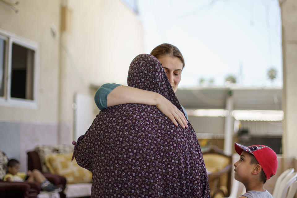 Jewish resident Katya Michaelov, right, embraces her Arab neighbor, Obaida Hassuna, as she comes to pay her respects with her son, Adam, 7, after Hassuna's son, Musa, was killed in recent clashes between Arabs and Jews in the mixed Arab-Jewish town of Lod, central Israel, Saturday, May 29, 2021. "My child and their grandson are friends and play together," said Michaelov who has lived next to the Hassunas for seven years. "All of this is political and it's the people who are suffering." (AP Photo/David Goldman)