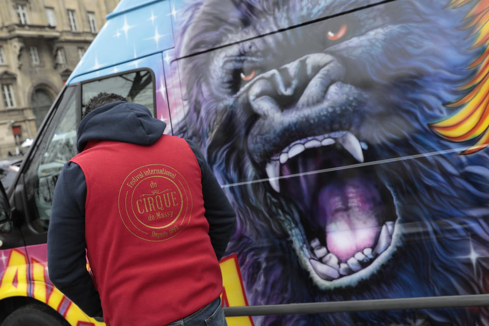 A circus worker stands by a circus van during a protest Tuesday, Jan.26, 2021. French lawmakers start debating Tuesday a bill that would ban using wild animals in traveling circuses and keeping dolphins and whales in captivity in marine parks, amid other measures to better protect animal welfare. Circus workers stage a protest outside the National Assembly to denounce what they consider "a mistake." (AP Photo/Lewis Joly)