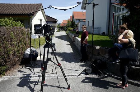 TV crews perpare for a statement in front of a house in Wuerenlingen, Switzerland May 10, 2015. REUTERS/Ruben Sprich