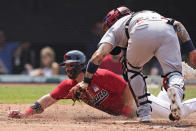 Cleveland Indians' Austin Hedges scores as St. Louis Cardinals' Yadier Molina is late on the tag in the fourth inning of a baseball game, Wednesday, July 28, 2021, in Cleveland. (AP Photo/Tony Dejak)