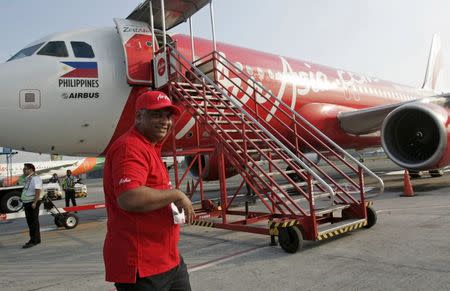 Tony Fernandes, CEO of AirAsia, walks near an AirAsia Airbus A320 at the domestic airport in Manila in this May 23, 2014 file photo. REUTERS/Romeo Ranoco/Files