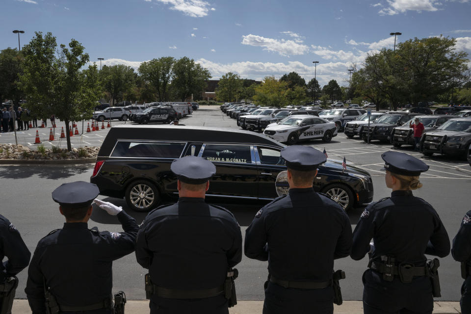 Arvada Police officers look on as the hearse carrying the casket of fallen Officer Dillon Vakoff leaves his memorial service on Friday, Sept. 16, 2022, at Flatirons Community Church in Lafayette, Colo. Vakoff was fatally shot while trying to break up a large family disturbance earlier in the week, in Arvada. (Timothy Hurst/The Gazette via AP)