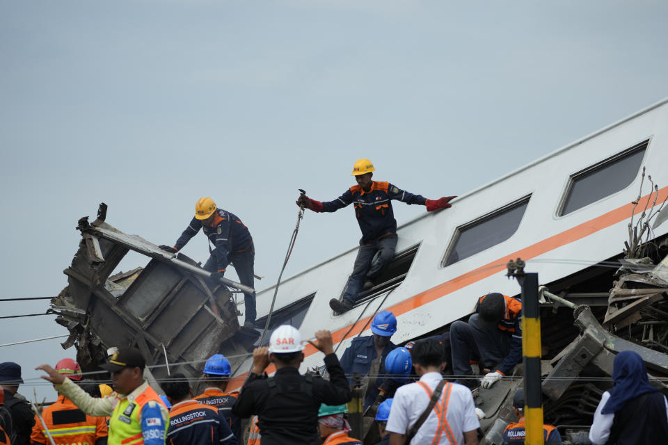 Rescuers inspect the wreckage after the collision between two trains in Cicalengka, West Java, Indonesia, Friday, Jan. 5, 2024. The trains collided on Indonesia's main island of Java on Friday, causing several carriages to buckle and overturn, officials said. (AP Photo/Achmad Ibrahim)