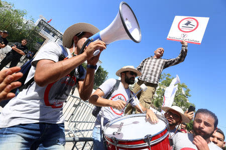 A demonstrator hits a drum during a demonstration against a bill that would protect those accused of corruption from prosecution in front of the Assembly of the Representatives of the People headquarters in Tunis, Tunisia September 13, 2017. The sign reads: "No. We will not forgive". REUTERS/Zoubeir Souissi