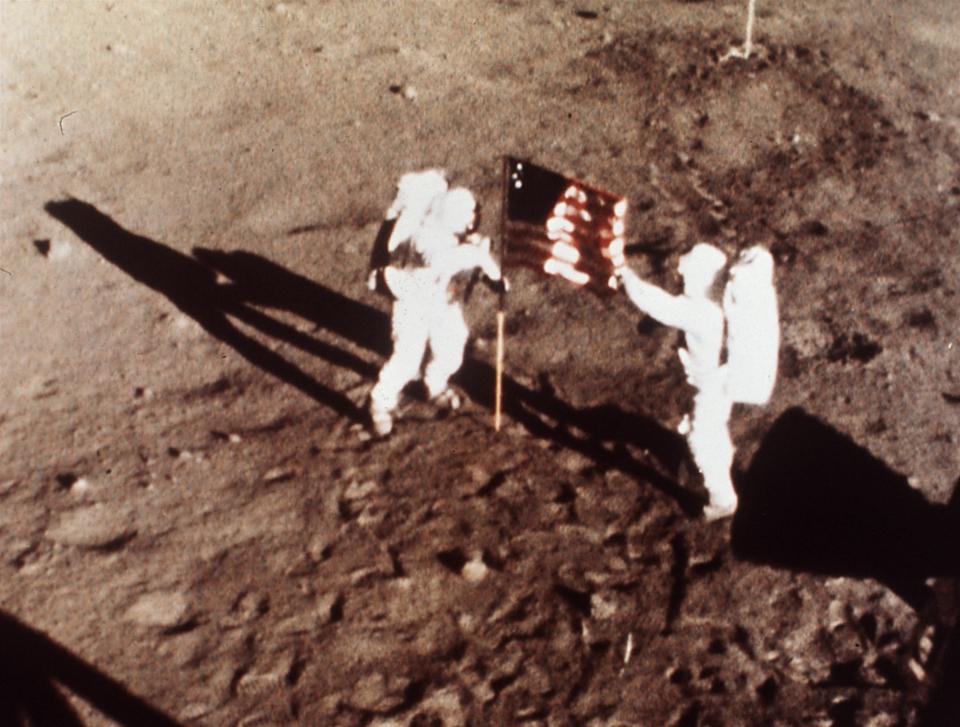 A July 20, 1969 file photo shows Apollo 11 astronauts Neil Armstrong and Edwin E. "Buzz" Aldrin, the first men to land on the moon, plant the U.S. flag on the lunar surface.  Photo was made by a 16mm movie camera inside the lunar module, shooting at one frame per second.