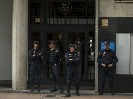Spanish riot National Police officers stand guard outside the apartment block which is the residence of former People's Party minister and former managing director of the International Monetary Fund, Rodrigo Rato, during an inspection in Madrid, April 16, 2015. REUTERS/Sergio Perez