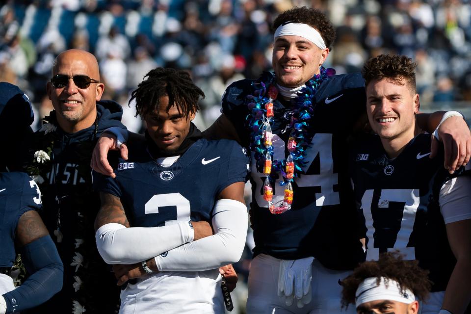 Penn State seniors Theo Johnson, Johnny Dixon (3) and Mason Stahl (17) pose for a group photo with their teammates and head coach James Franklin during senior day at Beaver Stadium Saturday, Nov. 18, 2023, in State College, Pa. The Nittany Lions won, 27-6.