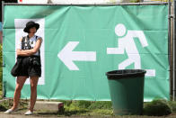 BERLIN, GERMANY - JULY 21: An attendee yawns by an exit sign at the second annual Hipster Olympics on July 21, 2012 in Berlin, Germany. With events such as the "Horn-Rimmed Glasses Throw," "Skinny Jeans Tug-O-War," "Vinyl Record Spinning Contest" and "Cloth Tote Sack Race," the Hipster Olympics both mocks and celebrates the Hipster subculture, which some critics claim could never be accurately defined and others that it never existed in the first place. The imprecise nature of determining what makes one a member means that the symptomatic elements of adherants to the group vary in each country, but the archetype of the version in Berlin, one of the more popular locations for those following its lifestyle, along with London and Brooklyn, includes a penchant for canvas tote bags, the carbonated yerba mate drink Club Mate, analogue film cameras, asymetrical haircuts, 80s neon fashion, and, allegedly, a heavy dose of irony. To some in Berlin, members of the hipster "movement" have replaced a former unwanted identity in gentrifying neighborhoods, the Yuppie, for targets of criticism, as landlords raise rents in the areas to which they relocate, particularly the up-and-coming neighborhood of Neukoelln. (Photo by Adam Berry/Getty Images)