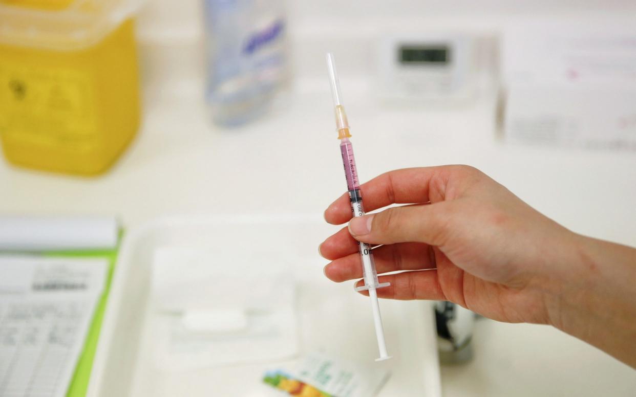 A nurse prepares a vaccine to be given to a child in a hospital in Beijing - REUTERS