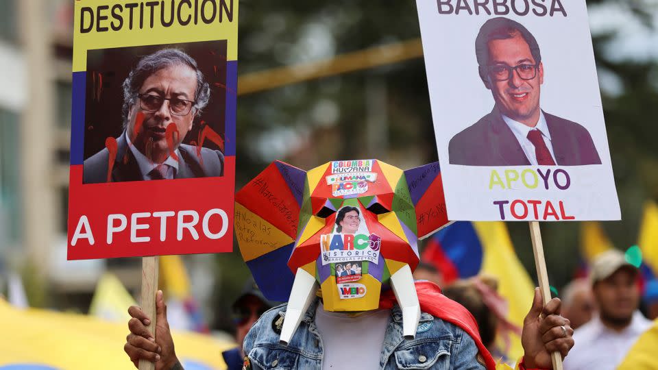 A demonstrator holds a tainted image of Colombian President Gustavo Petro (left) during an anti-government protest in the capital on August 16. - Luisa Gonzalez/Reuters