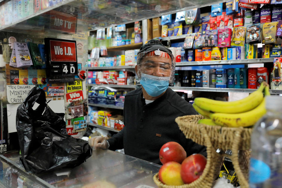 Bodega manager Rafael Perez wears a homemade face protector, fashioned from a water bottle, as he works in the Chinese Hispanic Grocery during the coronavirus disease (COVID-19) outbreak in the Lower East Side neighborhood of Manhattan, New York City, New York, U.S., April 2, 2020. REUTERS/Andrew Kelly
