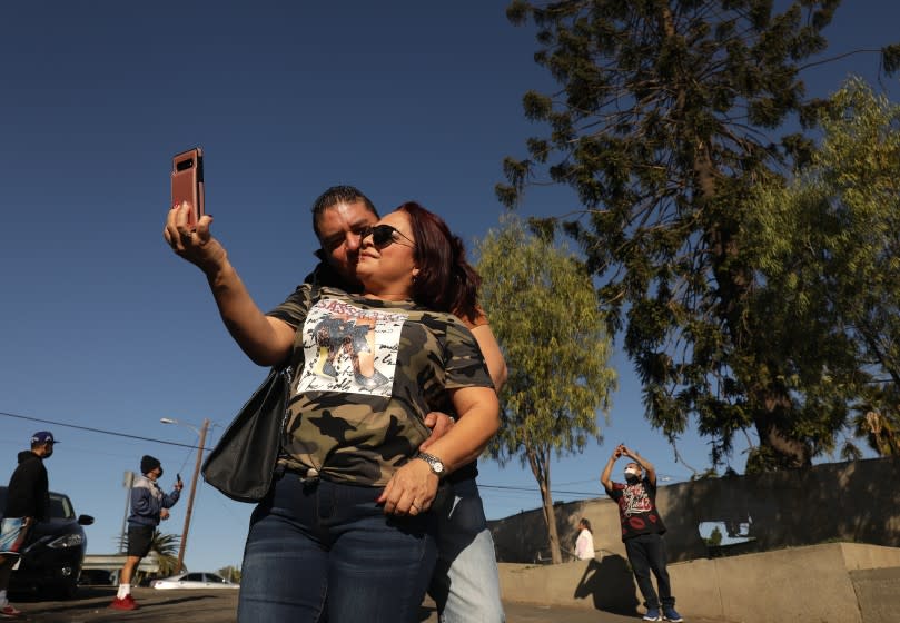 LOS ANGELES-CA-DECEMBER 31, 2020: Claudia Alva and her boyfriend Daniel Lopez traveled from Santa Fe, New Mexico to take a selfie in front of the world-famous pine tree in East Los Angeles known as "El Pino Famoso," which was featured in Taylor Hackford's 1993 film "Blood In Blood Out," after rumors it would be removed, on Thursday, December 31, 2020. (Christina House / Los Angeles Times)
