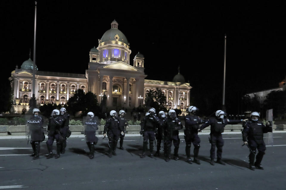 Serbian police officers guard the parliament building in Belgrade, Serbia, Tuesday, July 7, 2020. Thousands of people protested the Serbian president's announcement that a lockdown will be reintroduced after the Balkan country reported its highest single-day death toll from the coronavirus Tuesday. (AP Photo/Darko Vojinovic)