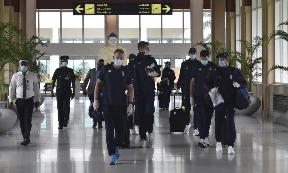 England cricketers walk along the arrivals terminal at Mattala Rajapaksa International airport in Hambantota, Sri Lanka, Sunday, Jan. 3, 2021. Team allrounder Moeen Ali was isolating in Sri Lanka on Monday after testing positive for the coronavirus upon his arrival in the South Asian country for the team's two-test cricket tour. Pace bowler Chris Woakes has been deemed as a possible close contact of Ali and was also observing a period of self-isolation in developments which have cast an early shadow on the tour that takes place weeks after a white-ball trip to South Africa was derailed by a spate of positive COVID-19 results. (AP Photo/Nuwan Jayasekara)