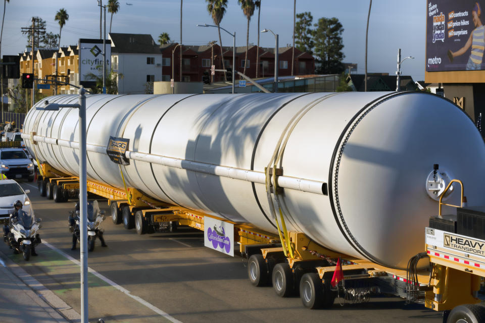 A shadow of a palm tree is cast upon the side of one of two rocket motors carefully being moved along Figueroa Street in Los Angeles, Wednesday Oct. 11, 2023. The giant rocket motors, required to display the retired NASA space shuttle Endeavour as if it’s about to blast off, were trucked over two days from Mojave Air and Space Port to LA’s Exposition Park, where the California Science Center’s Samuel Oschin Air and Space Center is being built to display Endeavour. (AP Photo/Richard Vogel)