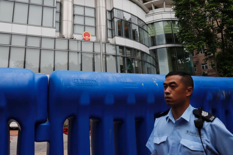 A police officer walks past water filled barriers after the opening ceremony of a temporary national security office, in Hong Kong