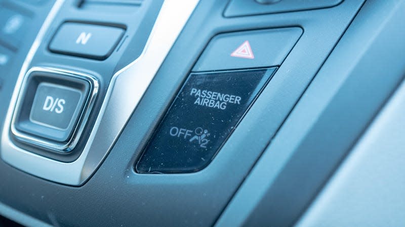 Close-up of passenger airbag indicator light on dashboard of a car.