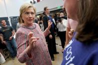 U.S. Democratic presidential candidate Hillary Clinton crosses her fingers as she talks with a worker at Galvanize, a learning community for technology, in Denver, U.S. June 28, 2016. REUTERS/Rick Wilking