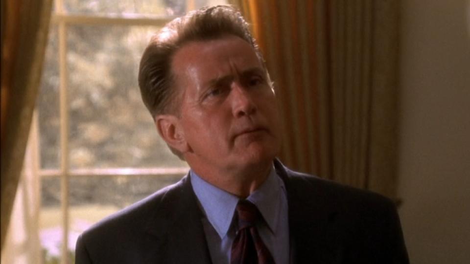 Martin Sheen as President Bartlet looks up as he speaks with someone on The West Wing.