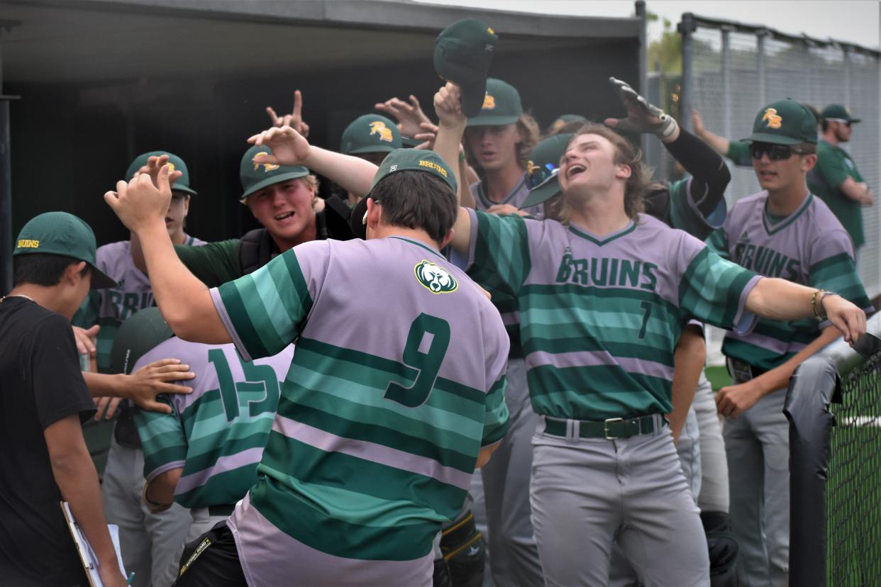 The Rock Bridge dugout celebrates as Justus Poppa (15) scored a run during the Bruins' 12-3 win over Blue Springs in the Class 6 District 5 semifinals on Tuesday.