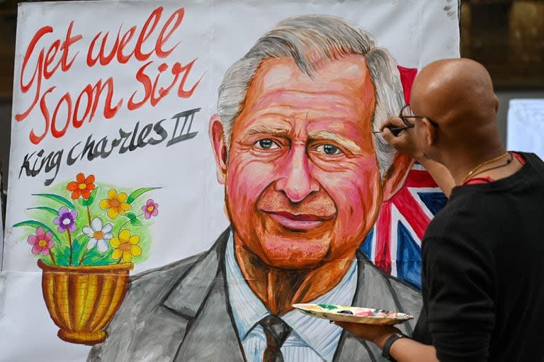 Un artista da los toques finales a una pintura del rey Carlos III de Gran Bretaña para desearle una pronta recuperación, frente a una escuela de arte en Mumbai el 6 de febrero de 2024. (AFP / Punit Paranjpe)