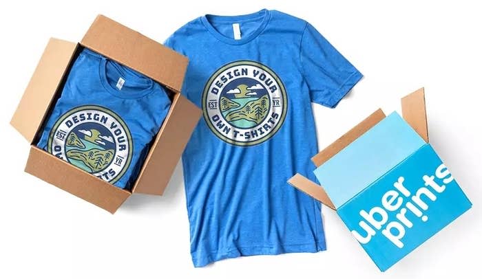 a blue T-shirt featuring a logo with text reading "Design your own T-shirts" next to a box filled with shirts of the same style