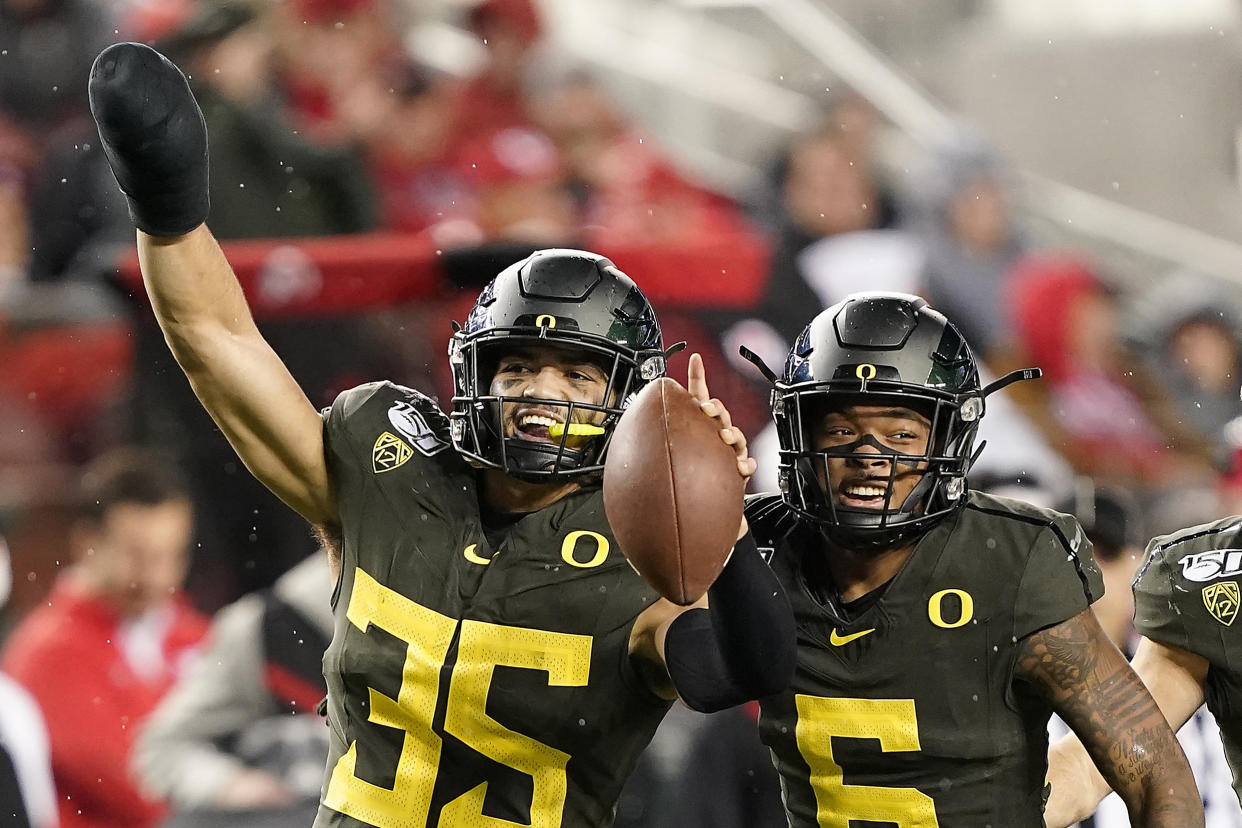 FILE - In this Dec. 6, 2018, file photo, Oregon linebacker Troy Dye (35) celebrates with teammate Deommodore Lenoir (6)  after Dye intercepted a Utah pass during the second half of an NCAA college football game for the Pac-12 Conference championship, in Santa Clara, Calif. Dye was selected to The Associated Press All-Pac 12 Conference team, Thursday, Dec. 12, 2019.  (AP Photo/Tony Avelar, File)