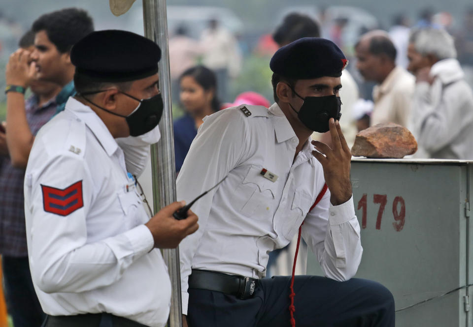 Delhi Traffic policemen stand at a crossing wearing pollution masks amidst smog in New Delhi, India, Thursday, Nov. 7, 2019. The air quality index stood at 273 on Thursday after authorities declared a health emergency last weekend when the index crossed 500 — 10 times the level considered healthy by WHO standards. (AP Photo/Manish Swarup)