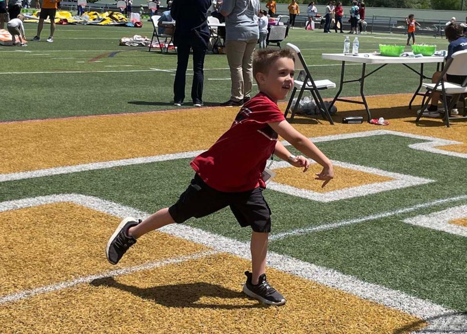 Oakland Felder, 7, gives the dunking booth his best shot while saying “Pow!” for extra strength at the Family Friendzy fundraiser at Knoxville Catholic High School Sunday, April 30, 2023.