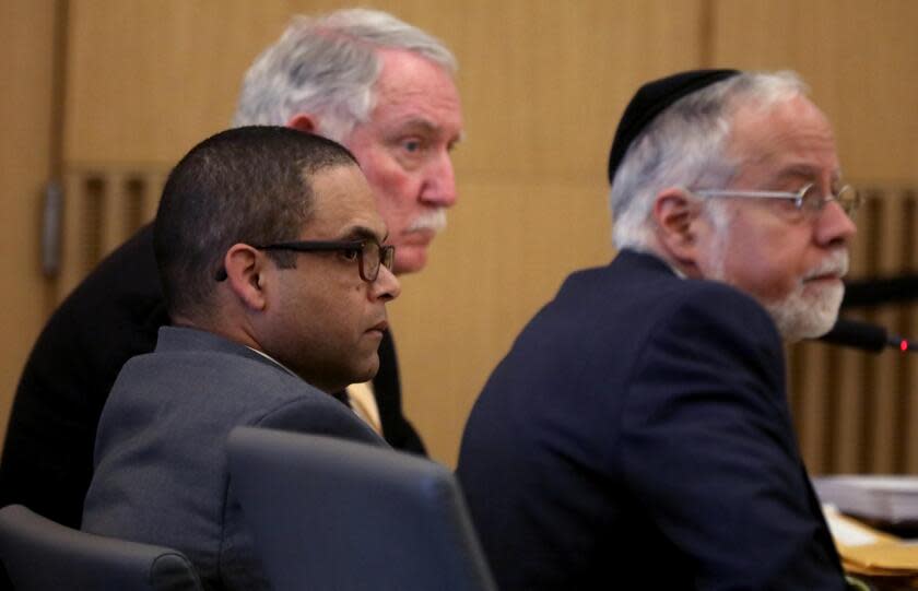 LONG BEACH, CA - APRIL 4, 2024 - - Eddie F. Gonzalez, 51, center, with lead attorney Michael Schwartz, right, and co-counsel listen as a witness testifies during opening day proceedings in the trial of People vs. Eduardo Gonzalez in Dept. 21 at the Gov. George Deukmejian Courthouse in Long Beach on April 4, 2024. Gonzalez, a former Long Beach school safety officer shot an unarmed 18-year-old in the head near a high school in September 2021. Eddie F. Gonzalez, 51, fired into a fleeing vehicle in late September after a fight between Manuela "Mona" Rodriguez and an unidentified 15-year-old girl one block from Millikan High School. (Genaro Molina/Los Angeles Times)