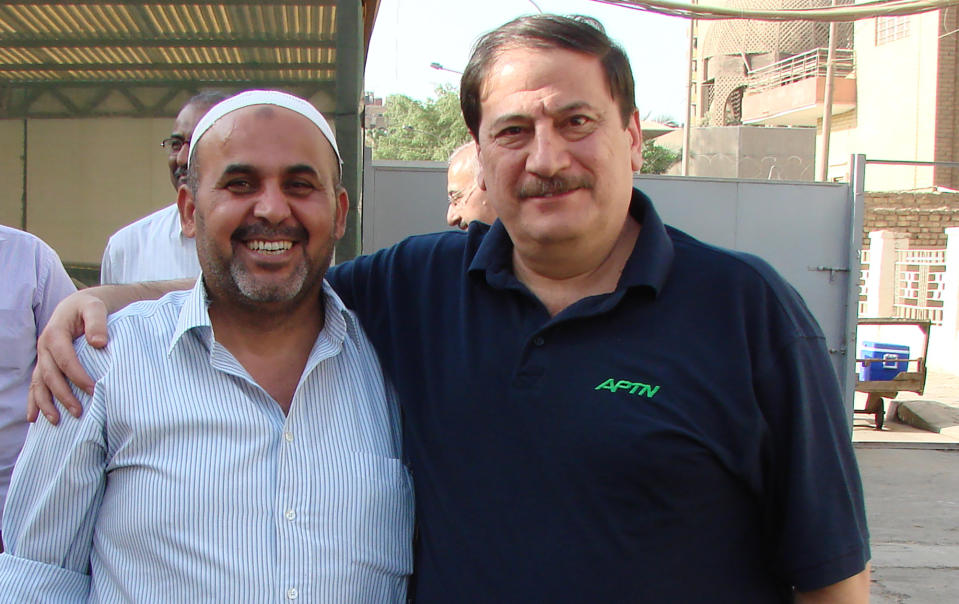 In this 2009 photo from left, Khodeir Majid and Iraq senior producer Ahmad Sami stand at the AP office in Baghdad. Majid, who covered Iraq’s numerous conflicts as a video producer and cameraman for the Associated Press over 17 years has died at the age of 64. Relatives said the cause of his death on Friday morning was complications due to the coronavirus. (AP Photo/Ahmad Sami)