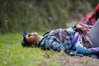 In this Sept 1, 2018 photo, fatigued Venezuelan Sandra Cadiz throws herself on the grass as she takes a break from walking to the Berlin paramo leading to the city of Bucaramanga, Colombia, on her journey to Peru. Like a growing number of desperate Venezuelans, Cadiz and her 10-year-old daughter journeyed by foot, risking their lives as they set out to cross an unforgiving terrain of frigid mountaintops, scorching rural valleys and perilous border crossings. (AP Photo/Ariana Cubillos)