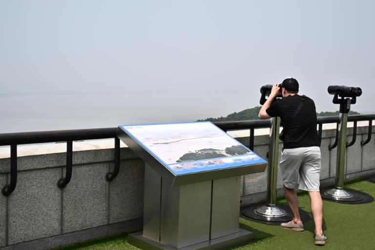 Una persona mira hacia Corea del Norte con unos binoculares en el Observatorio de Unificación de Odusan, en Paju, en Corea del Sur, el 11 de junio de 2024 (Anthony Wallace)