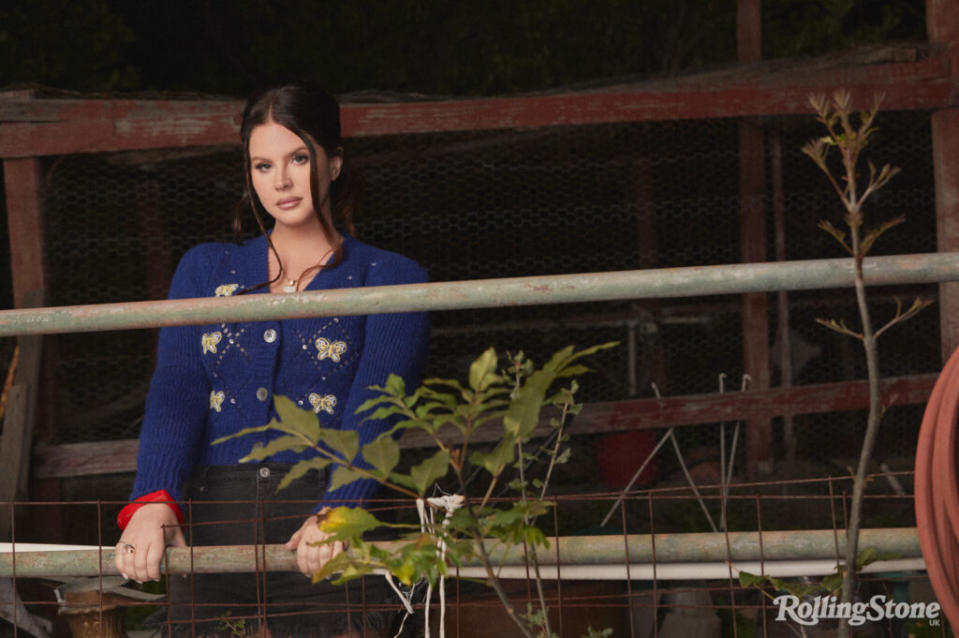 Lana wears knitwear by Alessandra Rich at MyTheresa, denim shorts by Ganni at Selfridges, necklace and rings by Pawnshop London, vintage Versace necklace at Susan Caplan, earrings by Swarovski, bracelets and boots, Lana’s own. (Picture: Chuck Grant. Styling: Joseph Kocharian)