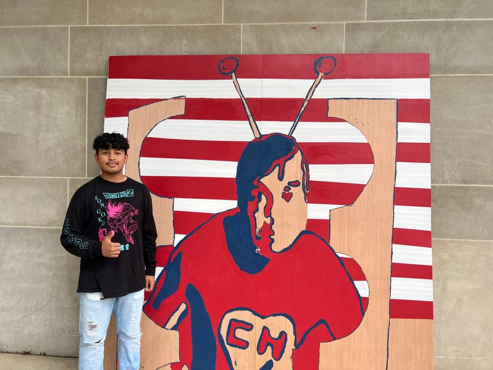 East High School student Carlos Guerra, 15, poses with the El Chapulín Colorado mural on May 20, 2022.