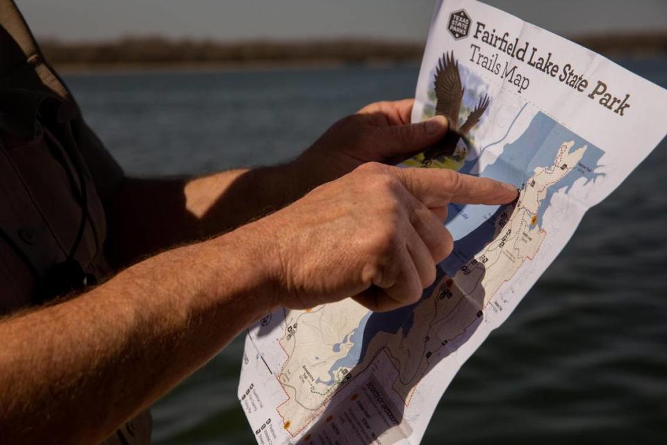 State Park Police Officer Kyle Ware points at a map of Fairfield Lake State Park in Fairfield on Feb. 27, 2023.