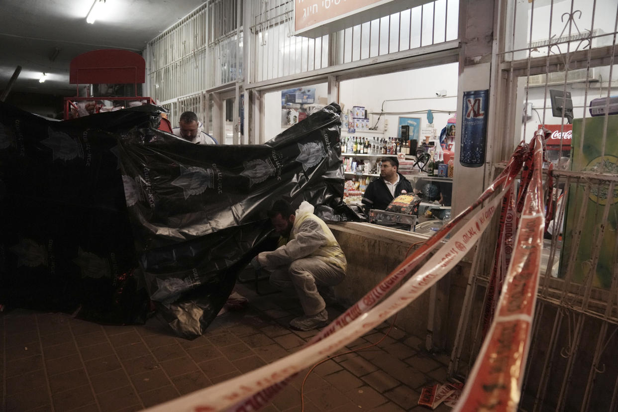 A member of Israeli Zaka Rescue and Recovery team cleans blood and human remains from the site where a gunman opened fire in Bnei Brak, Israel, Tuesday, March 29, 2022. A gunman on a motorcycle opened fire in central Israel late Tuesday, in the second fatal mass shooting rampage this week. The shooter was killed by police. (AP PhotoOded Balilty)