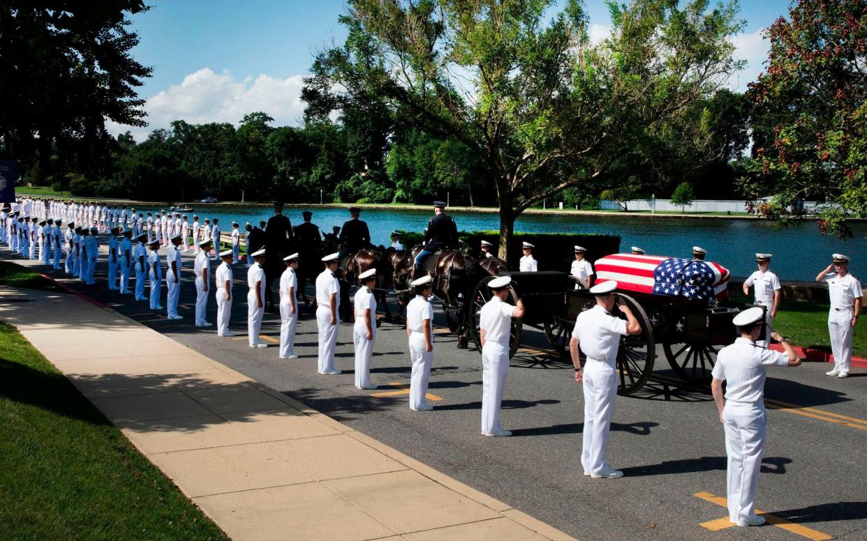 The horse-drawn caisson bearing the body of Senator John McCain moves through the grounds of the United Sates Naval Academy toward the cemetery  - AFP