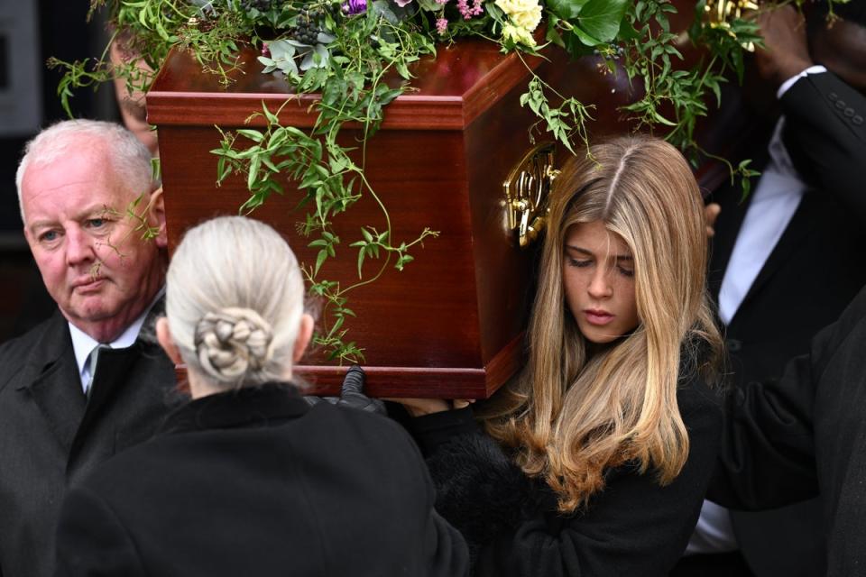 Darcey Draper, the daughter of Derek Draper, carries her father's coffin after the funeral mass at St Mary the Virgin Church (Getty Images)