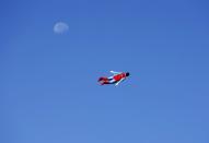 RNPS - PICTURES OF THE YEAR 2013 - A radio-controlled Superman plane, flown by designer Otto Dieffenbach, passes the moon during a test flight in San Diego, California June 27, 2013. Otto and business partner Ed Hanley are a small start-up company that creates flying radio-controlled planes, designed in the form of people, characters and objects, for commercial and promotional uses. REUTERS/Mike Blake (UNITED STATES - Tags: SOCIETY TPX)