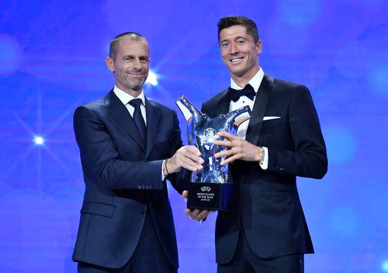 El delantero polaco del Bayern Munich Robert Lewandowski al recibir el premio al Futbolista del Año de la UEFA de parte del presidente del organismo del fútbol europeo, Aleksander Ceferin, en Ginebra, Suiza