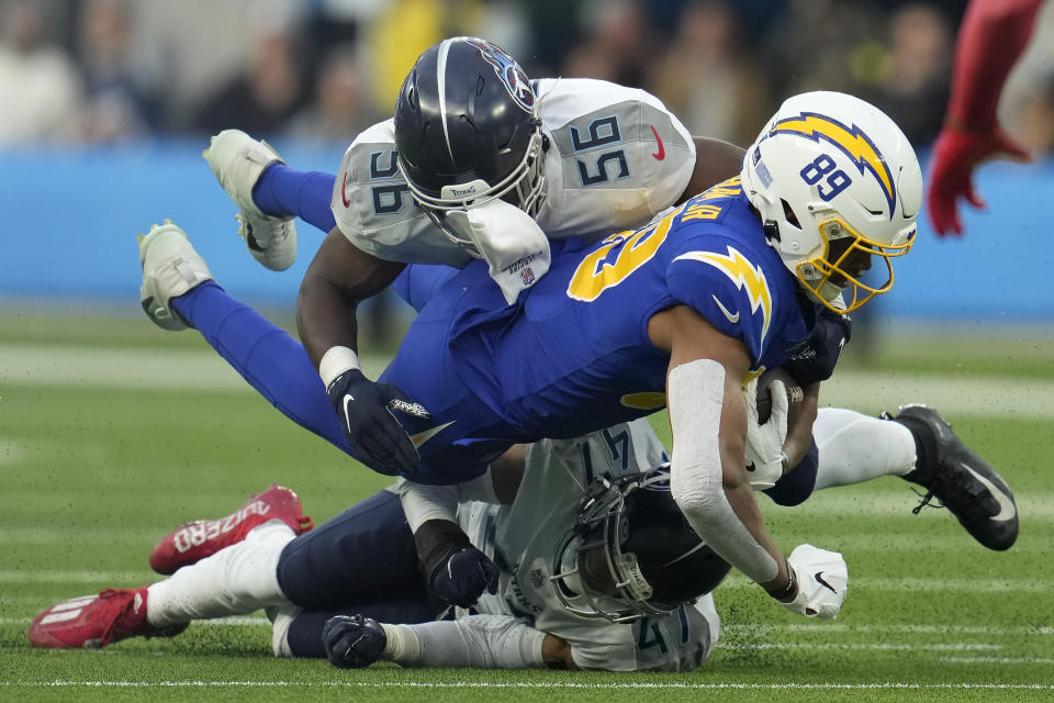 Los Angeles Chargers tight end Donald Parham Jr. (89) is tackled between Tennessee Titans linebacker Monty Rice (56) and safety Andrew Adams (47) during the first half of an NFL football game in Inglewood, Calif., Sunday, Dec. 18, 2022. (AP Photo/Marcio Jose Sanchez)